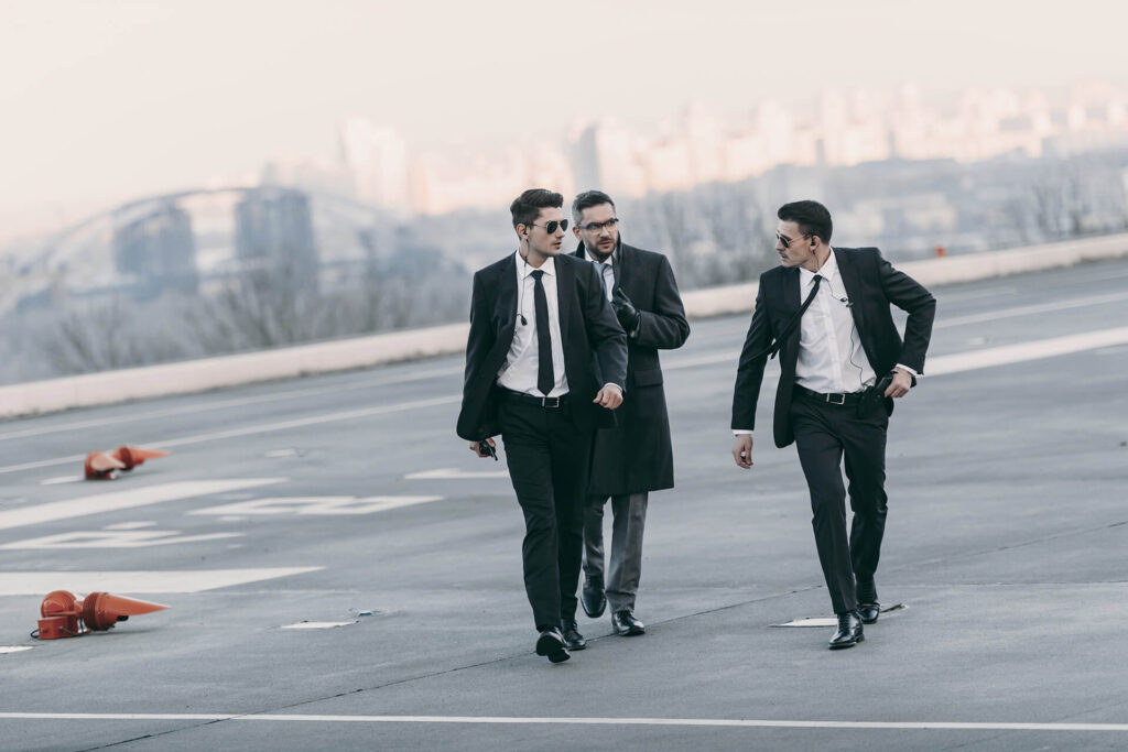 Businessman Walking With Bodyguards In Sunglasses 2022 12 16 18 36 17 Utc 1.jpg